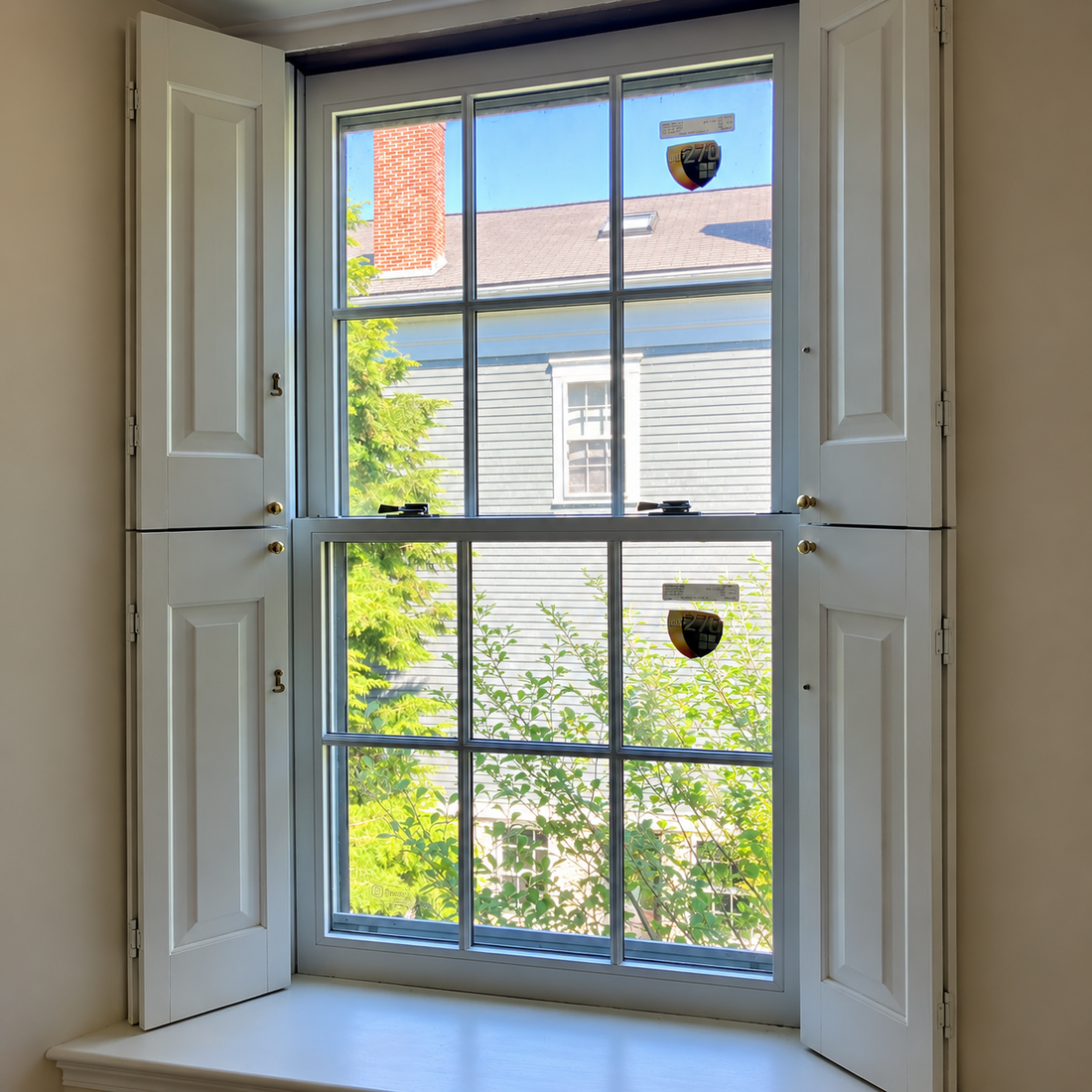 Replacement window sash installed in an existing wood window frame with original trim and shutters