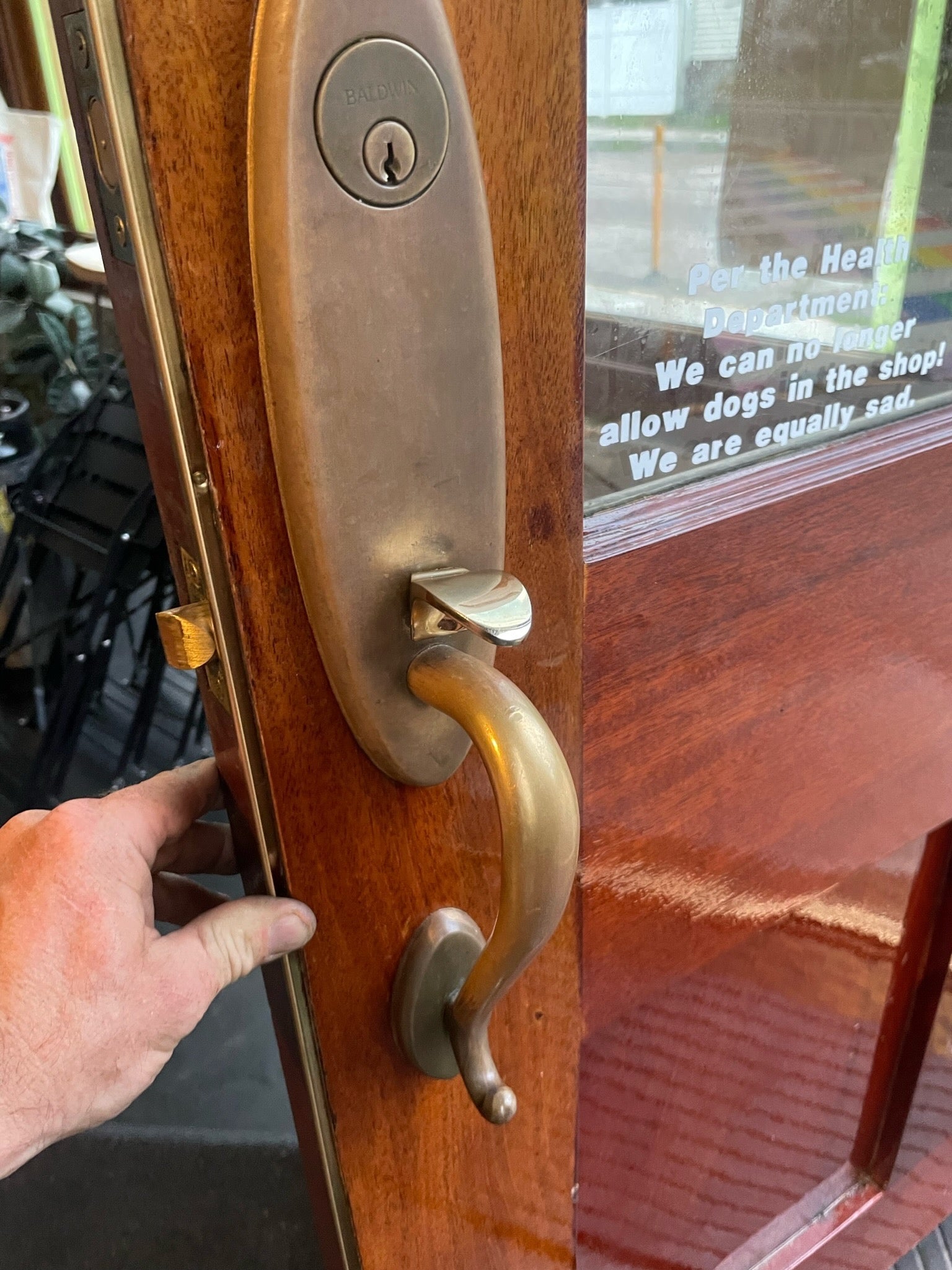 Solid-bronze L-shaped interlocking weatherstrip installed along the edge of a wood entry door