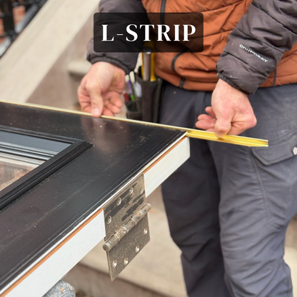 Craftsperson fitting a solid-bronze L-shaped interlocking weatherstrip to a wood door